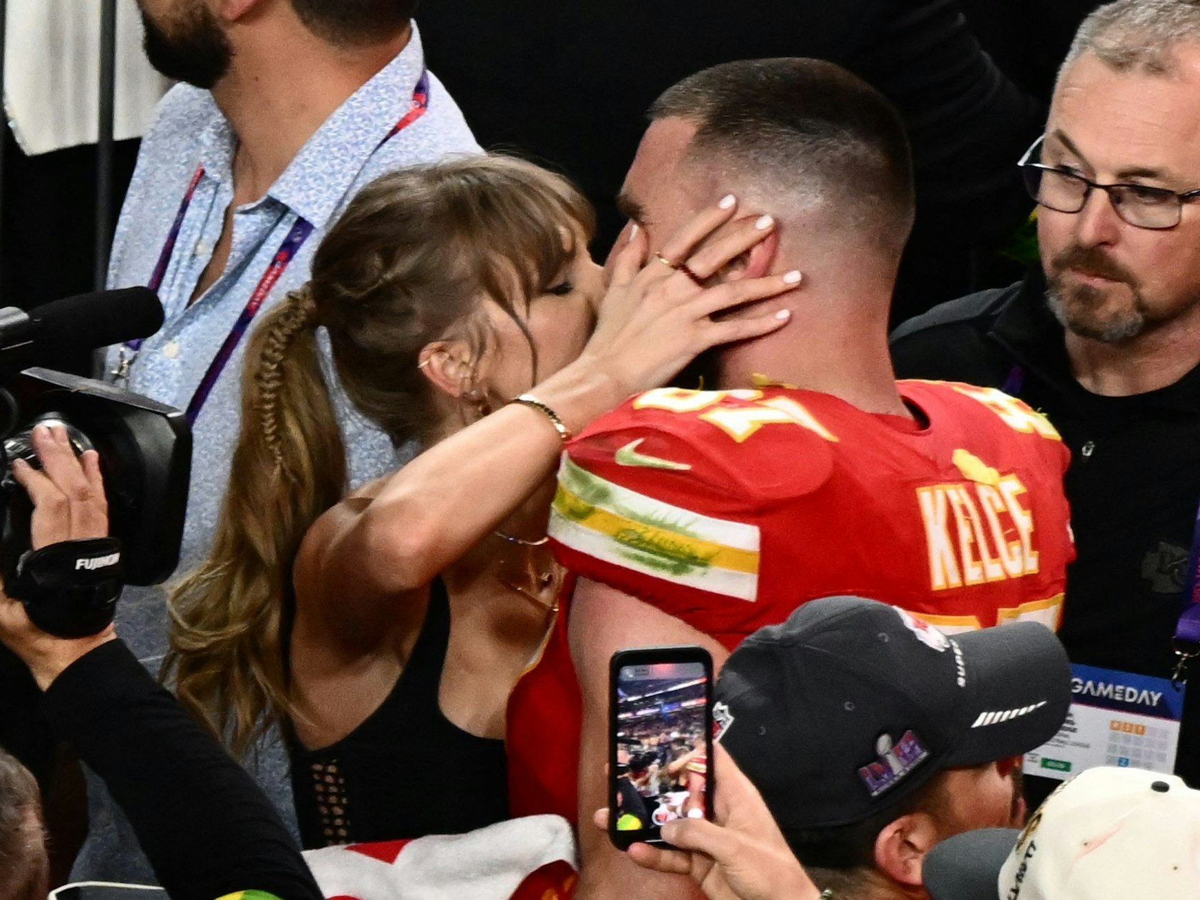 Taylor Swift küsst Kansas City Chiefs Tight End Travis Kelce nach dem Sieg. Swift ist zu einer wichtigen Marketinggröße in der NFL geworden, das Paar bewegt Massen. Könnte Swift auch die US-Wahl beeinflussen?