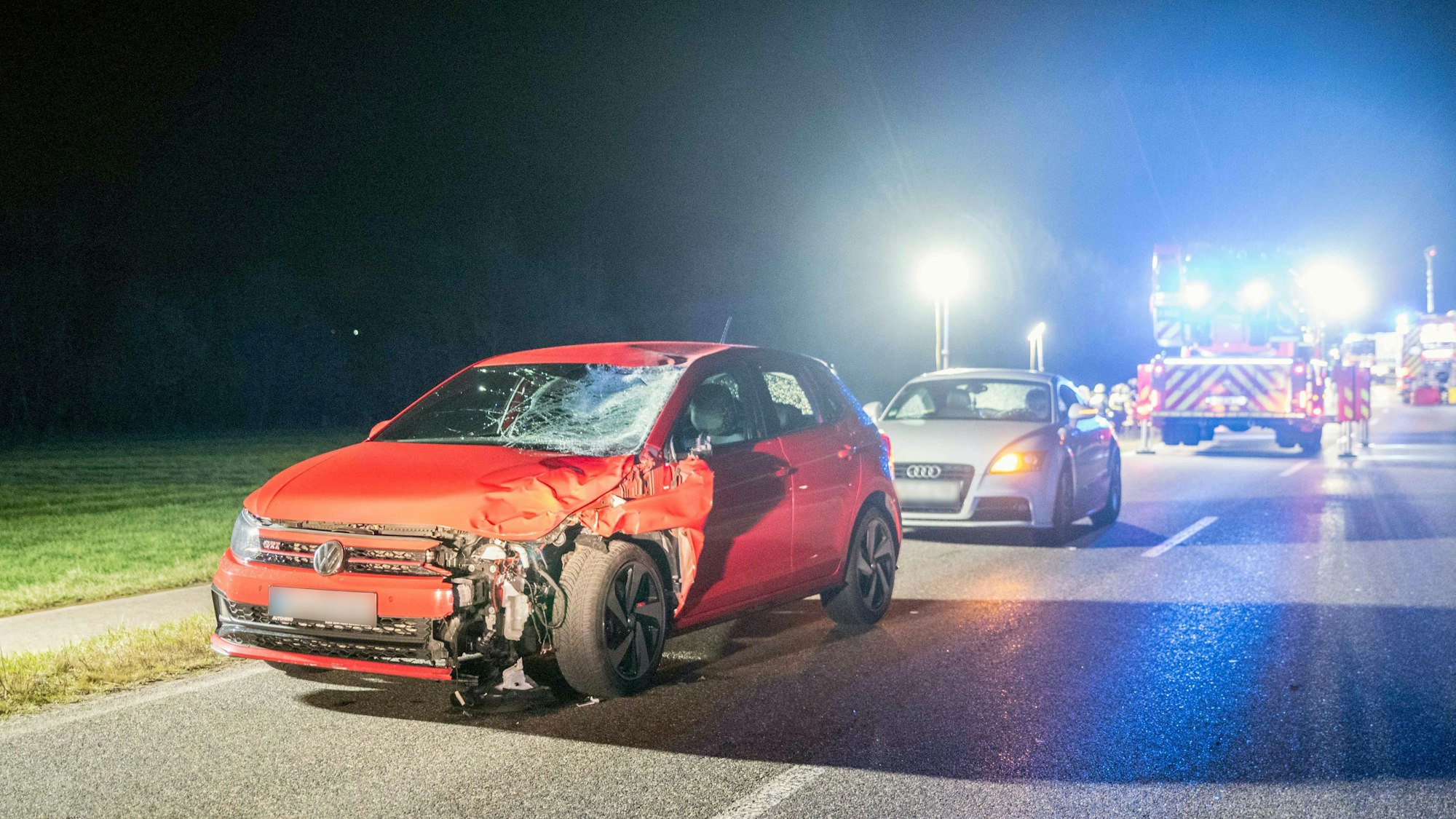 Ein stark beschädigtes Auto steht nach dem Zusammenprall mit zwei Menschen auf einer Landstraße.