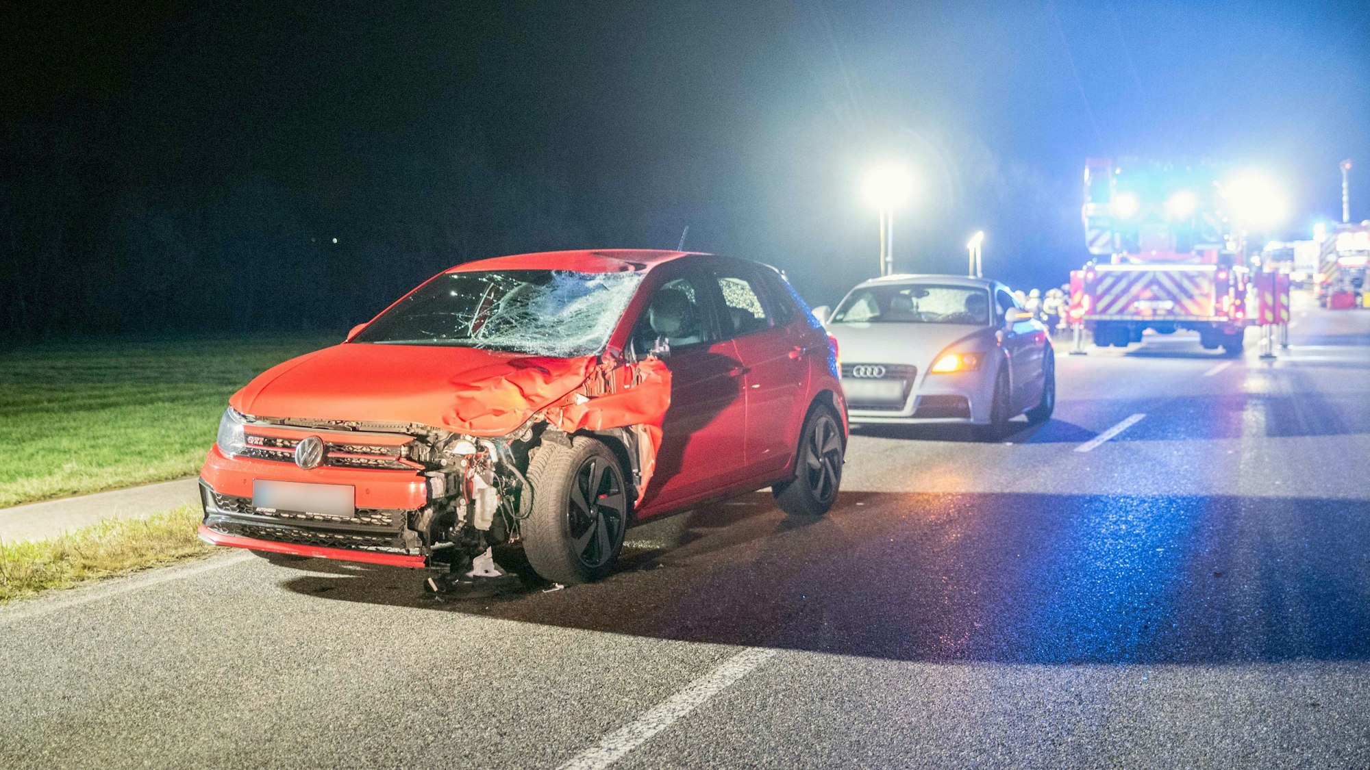 Ein stark beschädigtes Auto steht nach dem Zusammenprall mit zwei Menschen auf einer Landstraße.