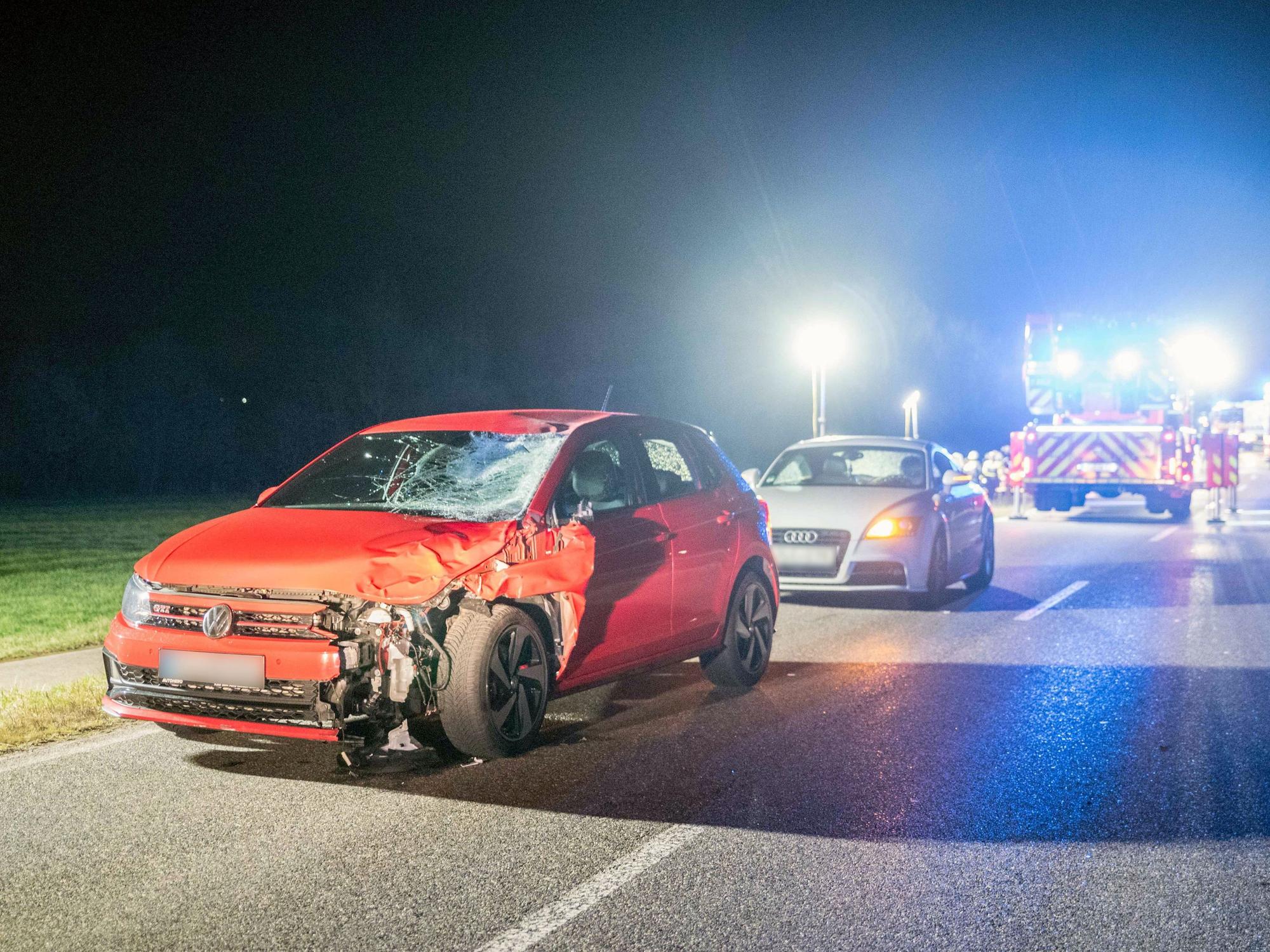 Ein stark beschädigtes Auto steht auf einer Landstraße, dahinter ein weiteres Auto.
