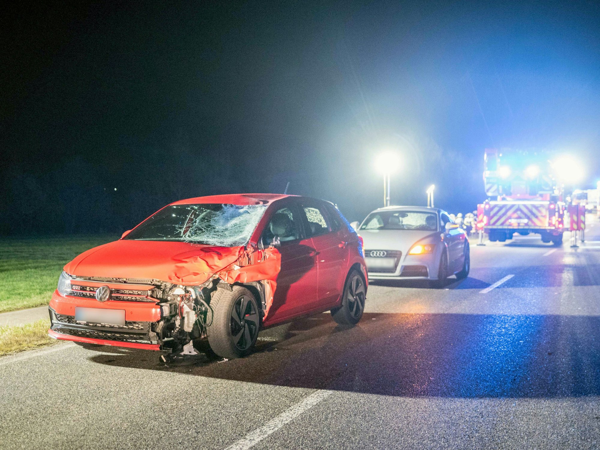 Ein stark beschädigtes Auto steht auf einer Landstraße, dahinter ein weiteres Auto.