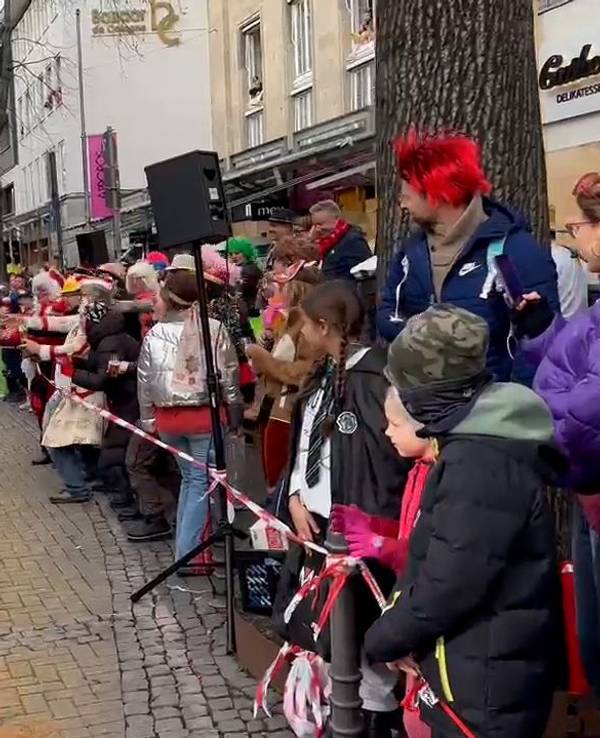 Tanzende Polizistin im Rosenmontagszug in Köln feiert mit den Jecken.