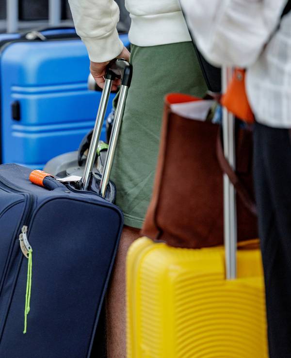 Fluggäste warten im Helmut Schmidt Flughafen vor dem Sicherheitscheck auf die Abfertigung.