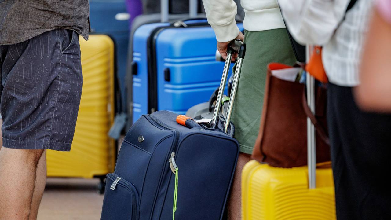 Fluggäste warten im Helmut Schmidt Flughafen vor dem Sicherheitscheck auf die Abfertigung.