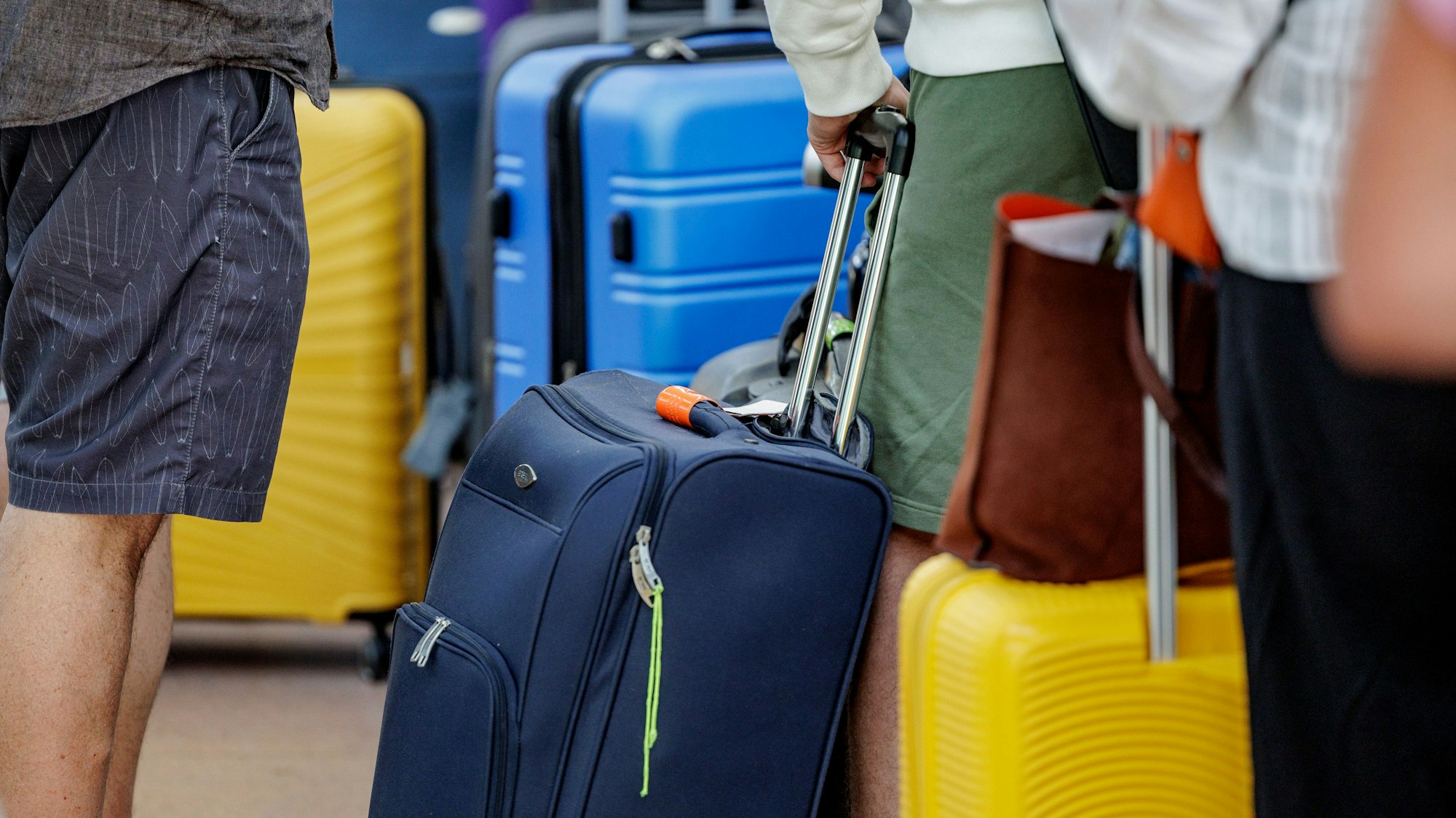 Fluggäste warten im Helmut Schmidt Flughafen vor dem Sicherheitscheck auf die Abfertigung.