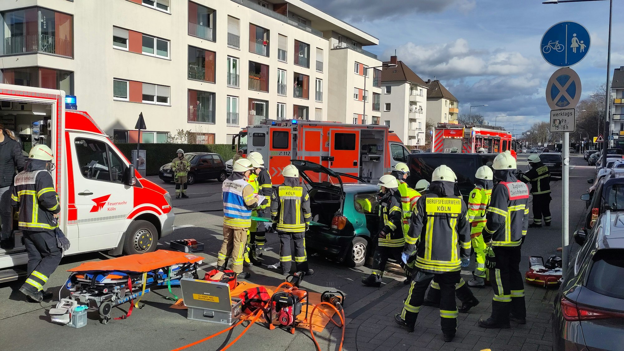 Einsatzkräfte der Feuerwehr stehen an einem Kleinwagen.