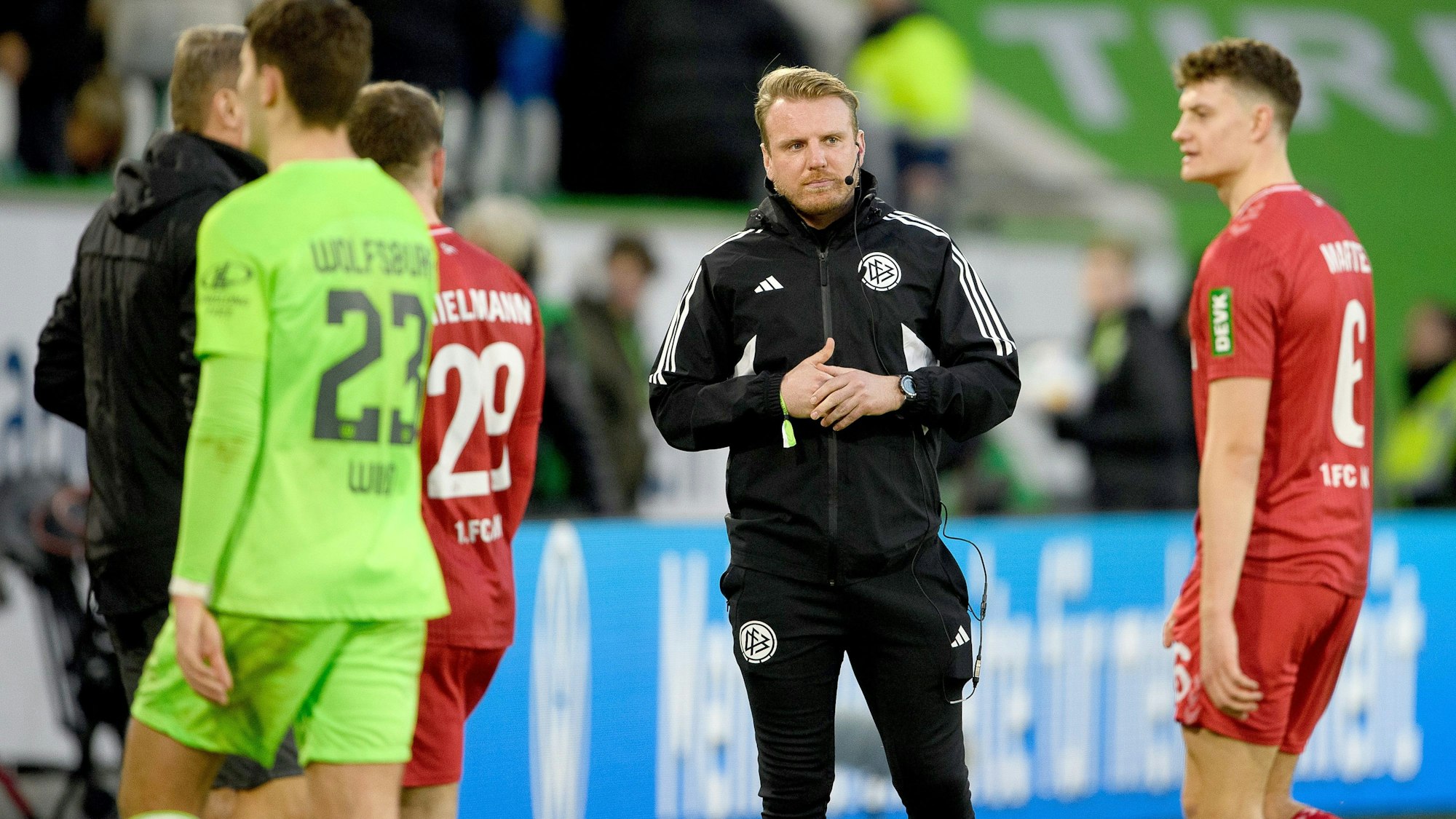 Tobias Krull steht als Vierter-Offizieller an der Seitenlinie. Ebenfalls auf dem Bild zu sehen, von Links nach Rechts: Jonas Wind, Jan Thielmann und Eric Martel