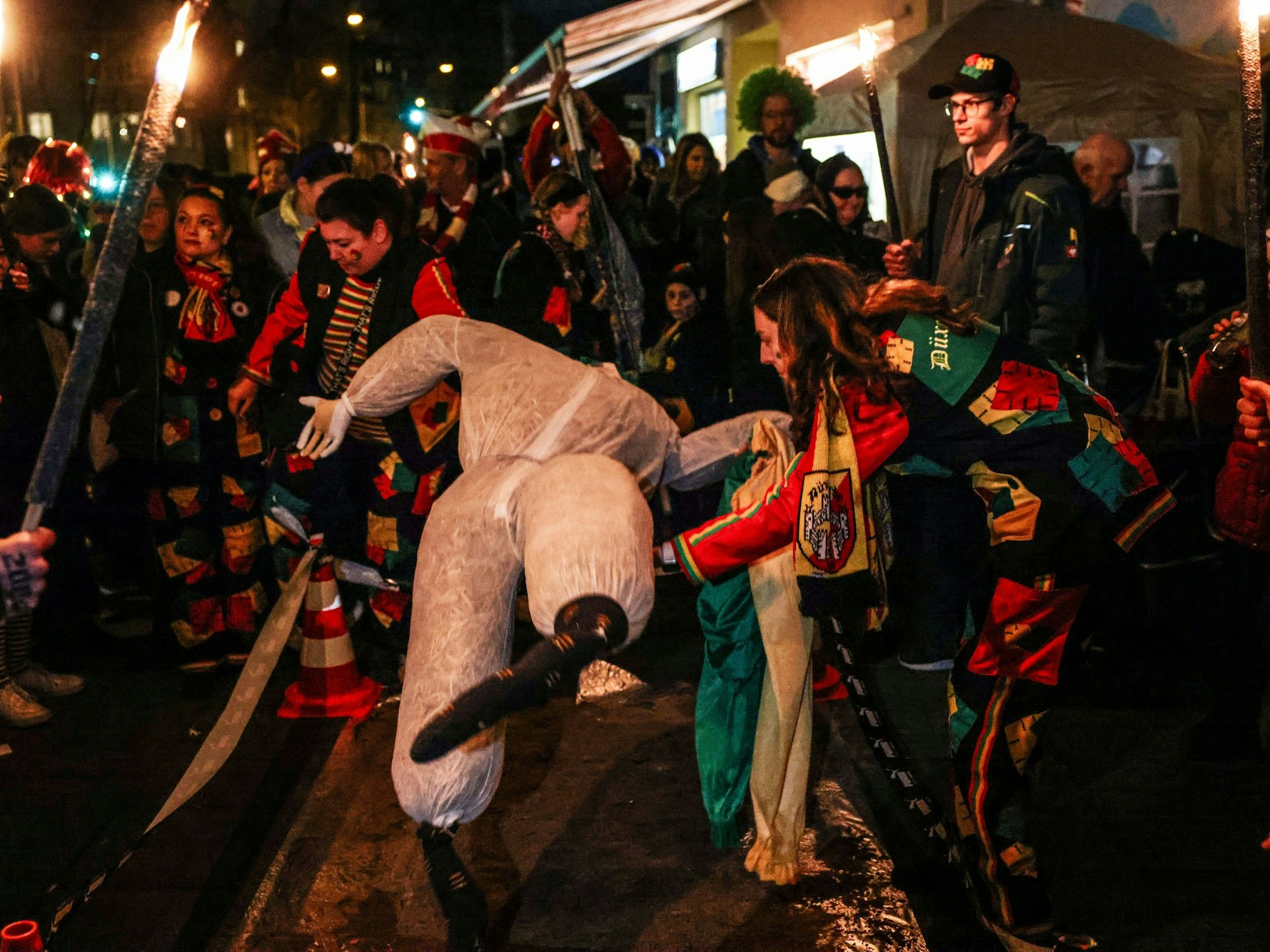 Karnevalistinnen und Karnevalisten legen den „Nubbel“ vor seiner Verbrennung am Veilchendienstag (13. Februar) auf die Straße.