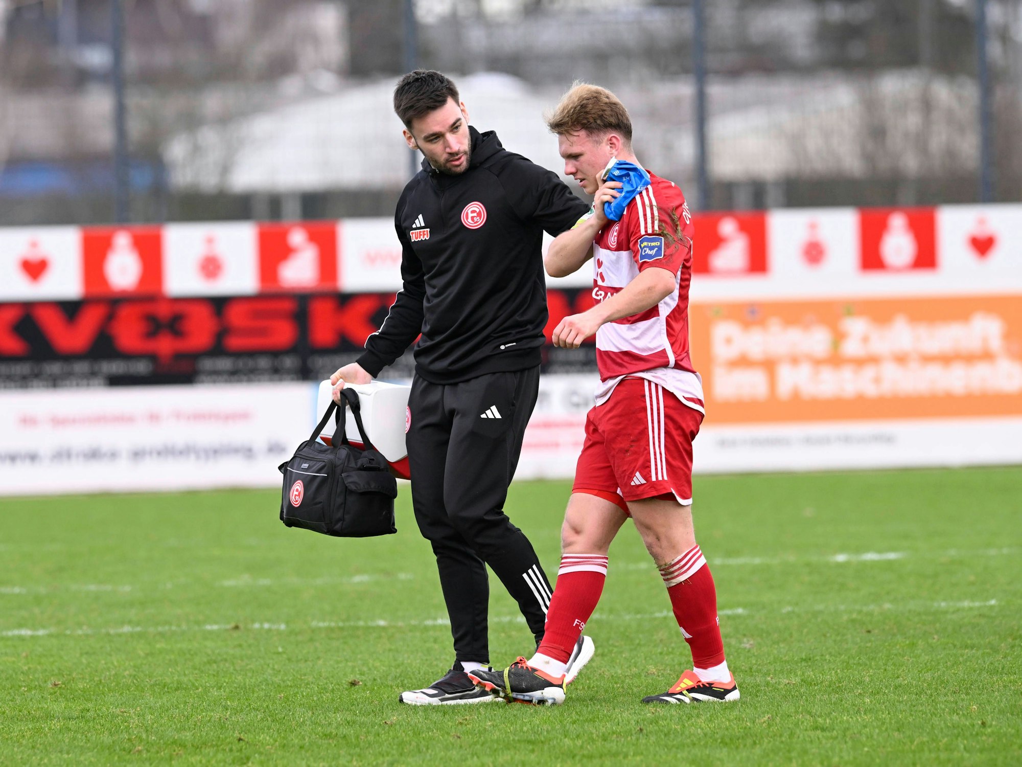 Fortuna Düsseldorfs Daniel Bunk geht verletzt vom Platz und drückt sich einen Eisbeutel auf die linke Schulter.