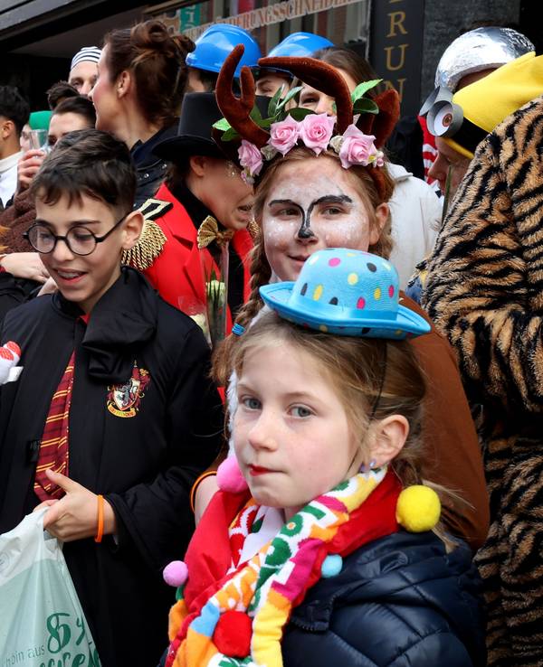 Kinder stehen am Straßenrand beim Kölner Rosenmontagszug.