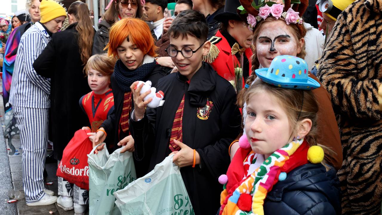 Kinder stehen am Straßenrand beim Kölner Rosenmontagszug.
