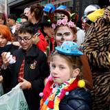 Kinder stehen am Straßenrand beim Kölner Rosenmontagszug.
