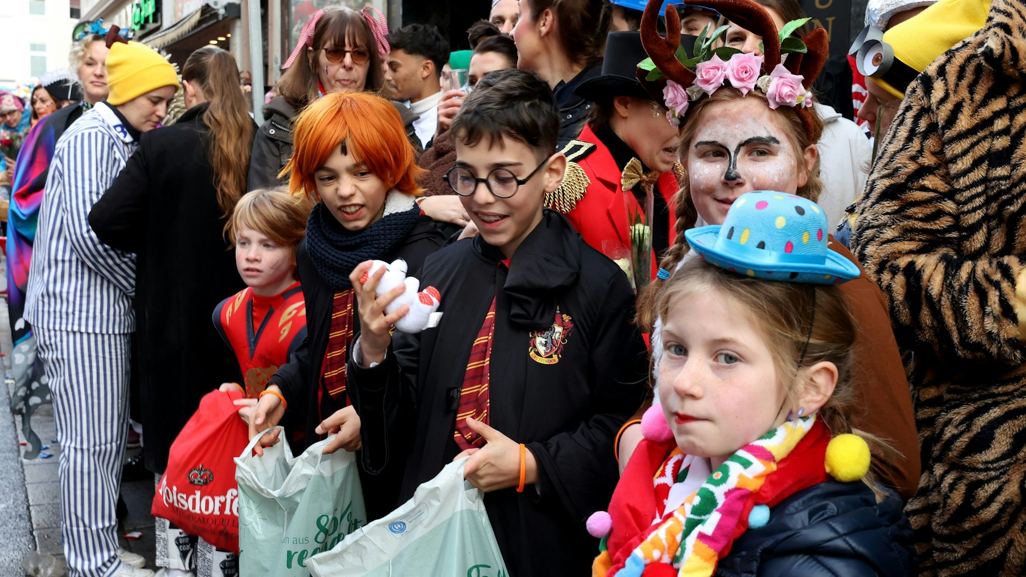 Kinder stehen am Straßenrand beim Kölner Rosenmontagszug.