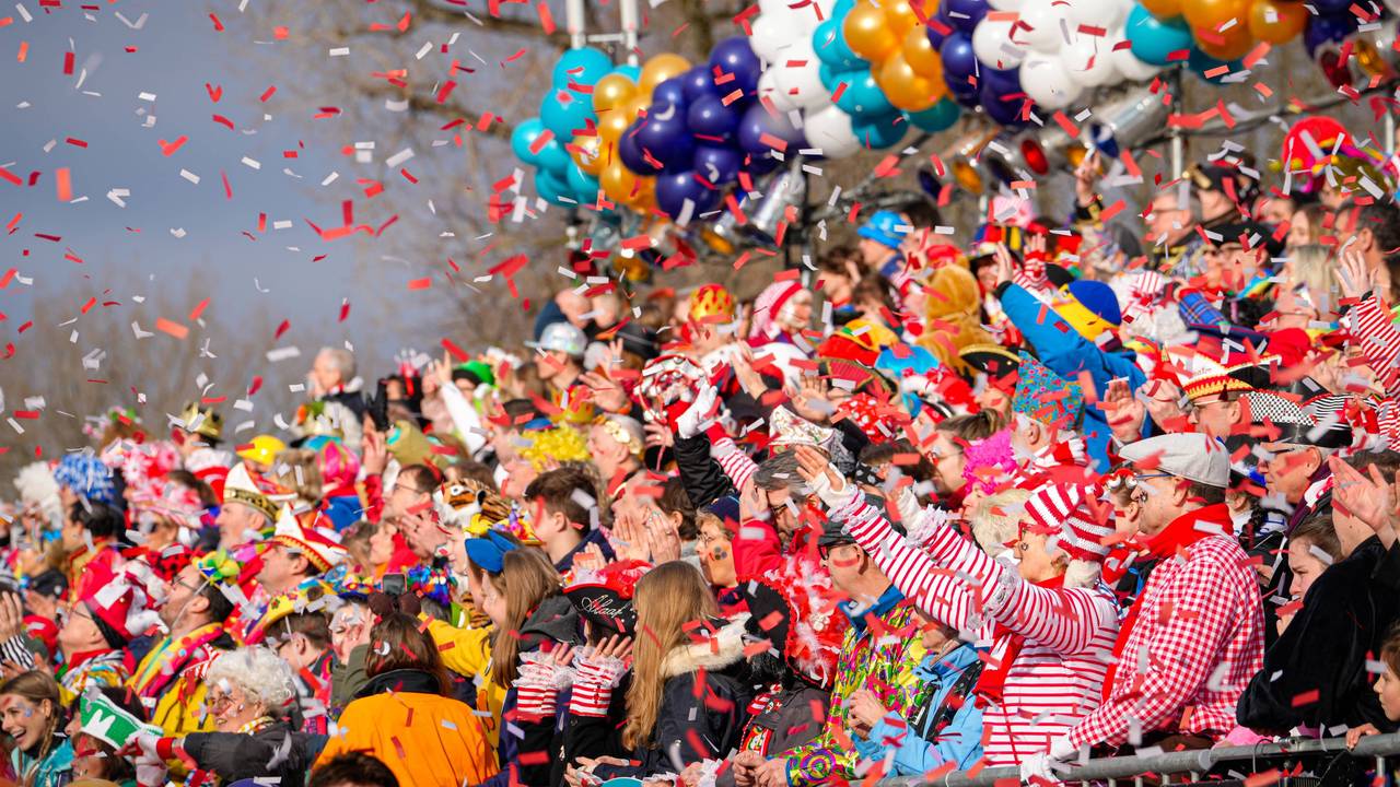 Menschen werfen Konfetti beim Kölner Rosenmontagszug.