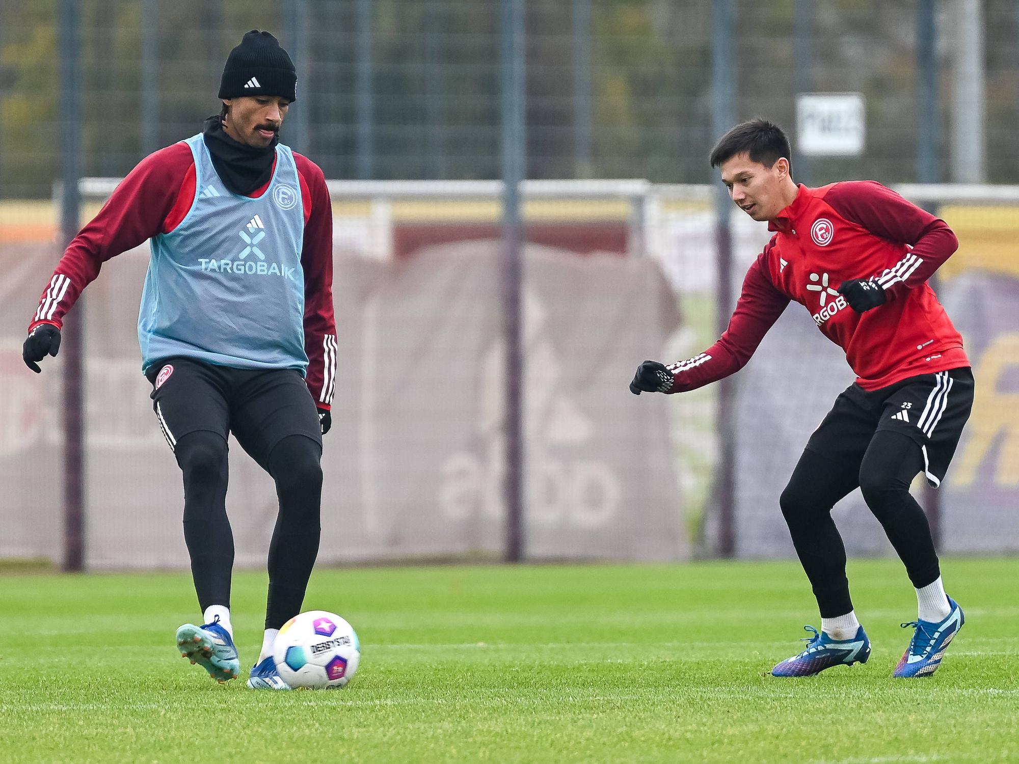 Fortuna Düsseldorfs Emmanuel Iyoha passt den Ball im Training, Shinta Appelkamp attackiert ihn dabei.