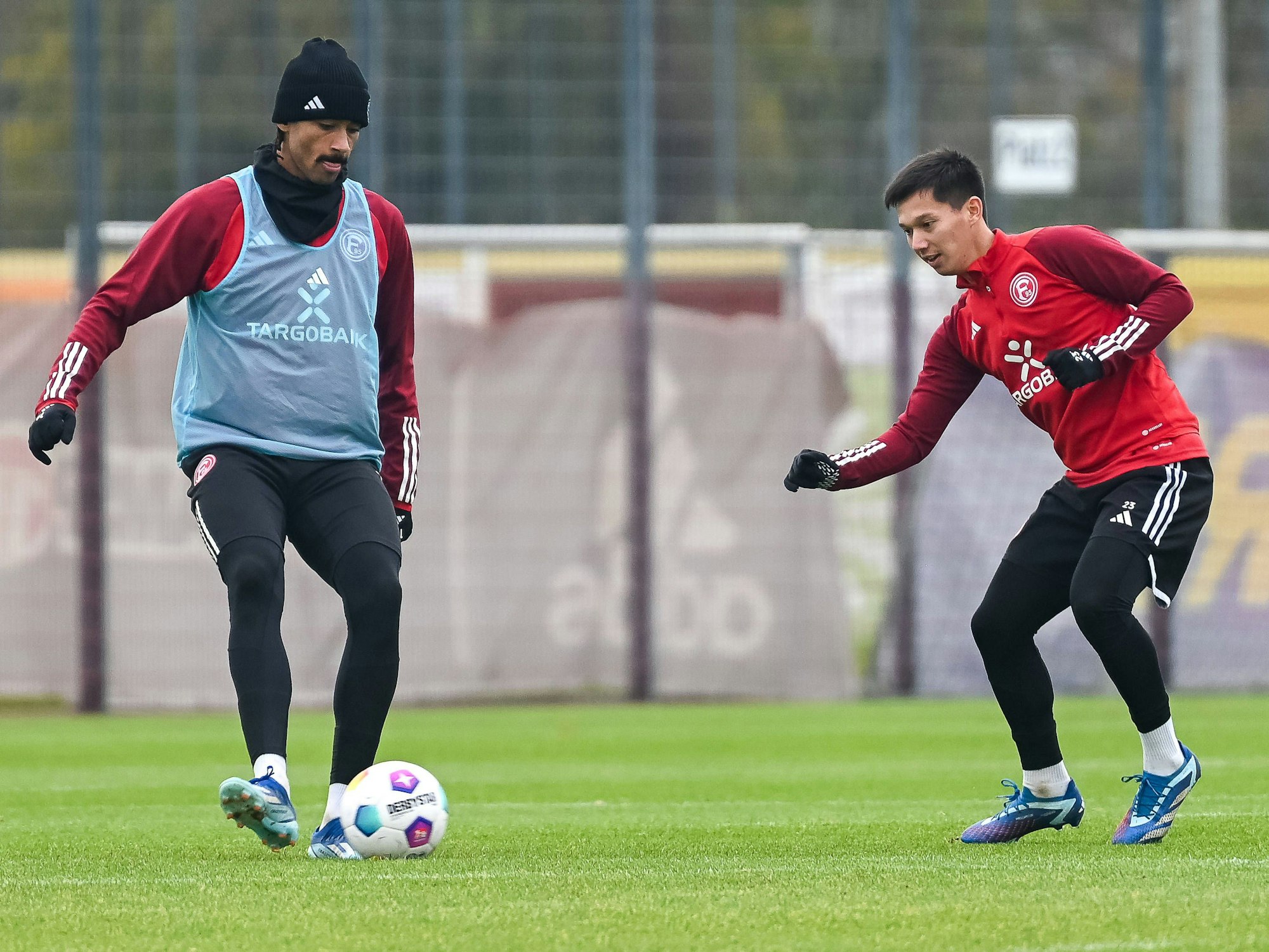 Fortuna Düsseldorfs Emmanuel Iyoha passt den Ball im Training, Shinta Appelkamp attackiert ihn dabei.