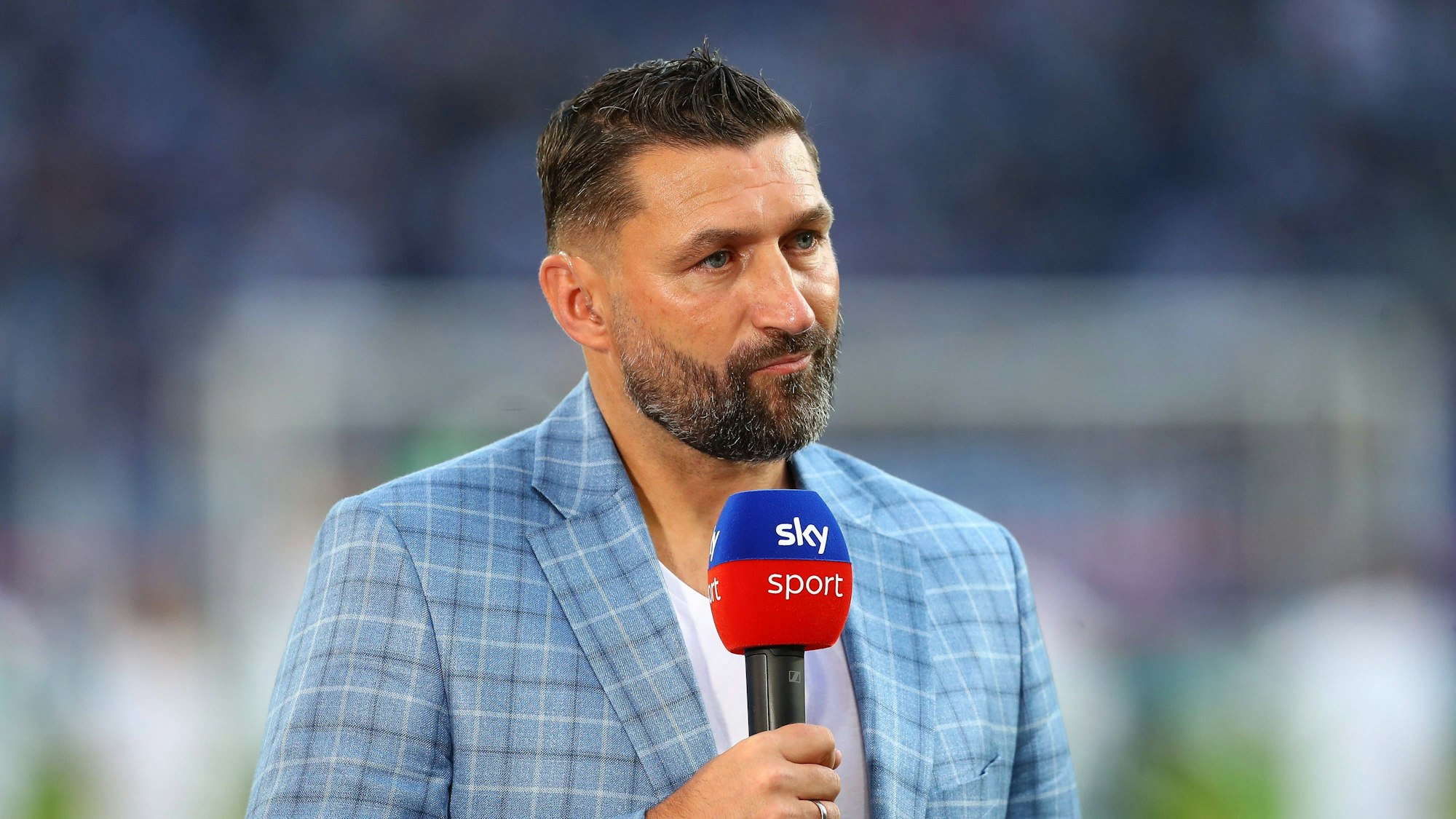 Sky-Experte Torsten Mattuschka steht mit Mikrofon beim Spiel Hannover 96 gegen den Hamburger SV im Stadion.