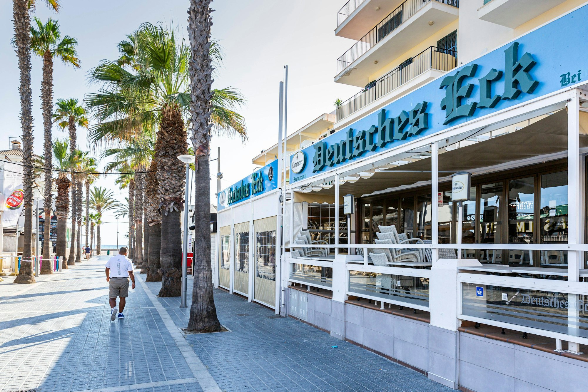 Eine Person läuft über die Straße vor dem „Deutschen Eck“ am Ballermann auf Mallorca