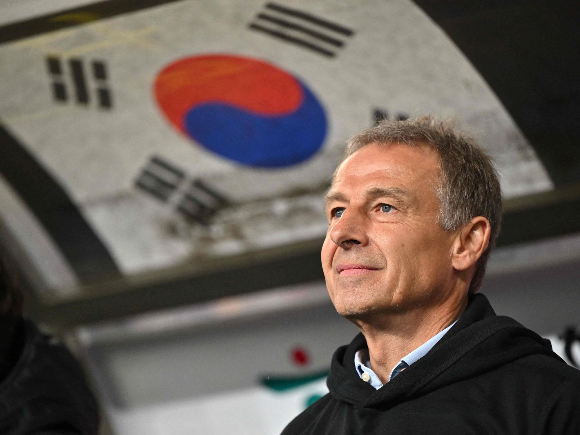 Trainer Jürgen Klinsmann bei einem Freundschaftsspiel zwischen Südkorea und Kolumbien mit der südkoreanischen Flagge im Hintergrund.