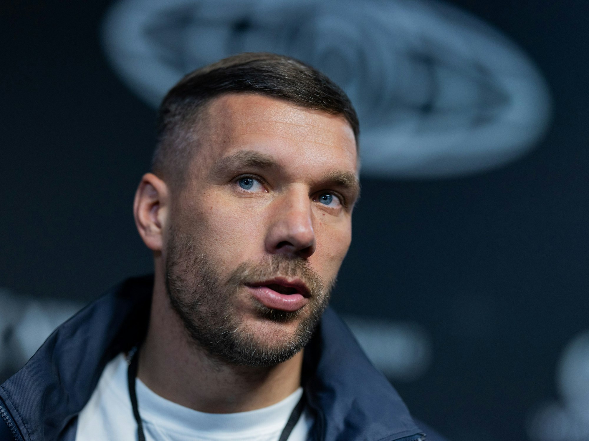 Lukas Podolski, Präsident der ·Baller League·, steht neben dem Spielfeld in der Motorworld.