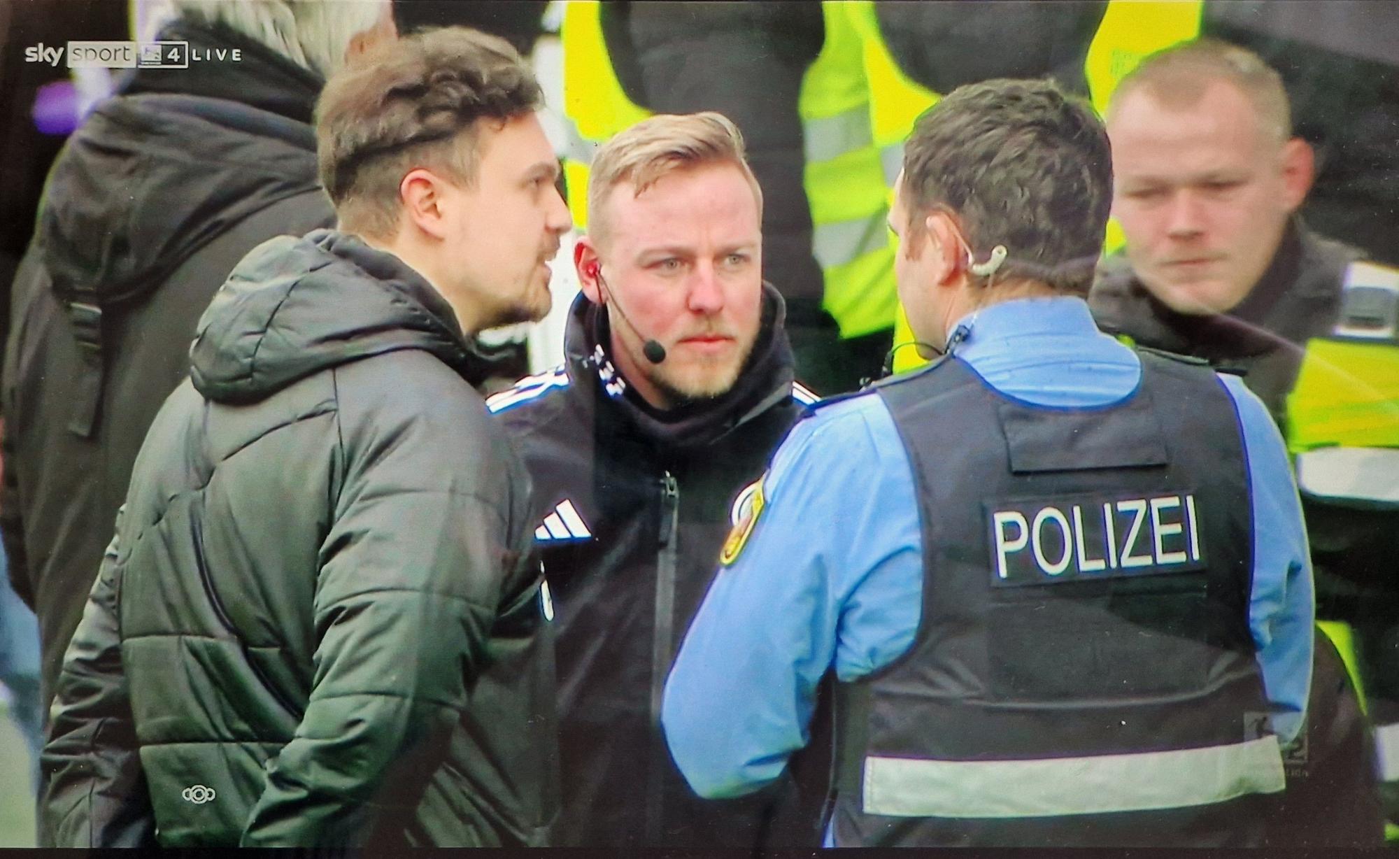 Ein Polizist spricht mit dem Vierten Offiziellen beim Spiel der 2. Bundesliga zwischen der SV Elversberg und dem VfL Osnabrück.