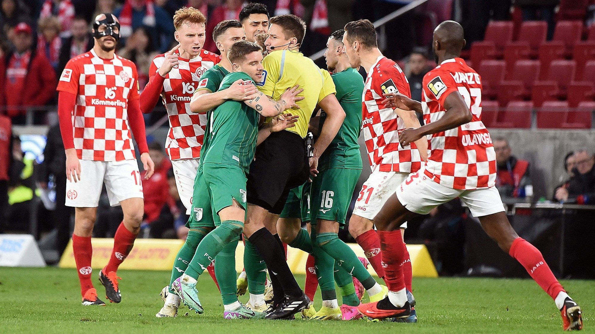 Rudelbildung beim Spiel zwischen Mainz 05 und dem FC Augsburg. Schiedsrichter Tobias Reichel hat alle Mühe, die Gemüter zu beruhigen.