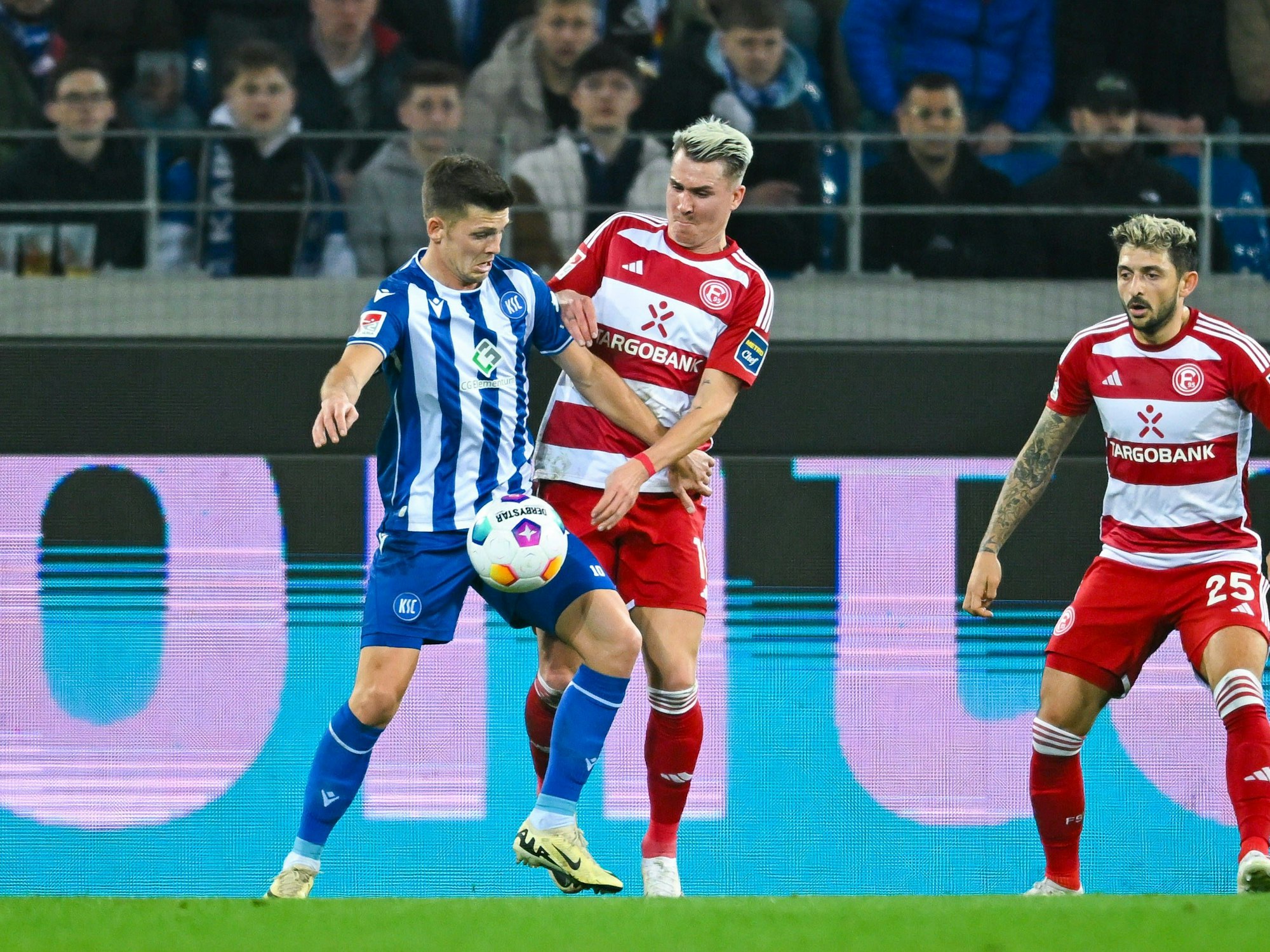 Felix Klaus kämpft mit Marvin Wanitzek um den Ball. Im Hintergrund zu sehen: Matthias Zimmermann.