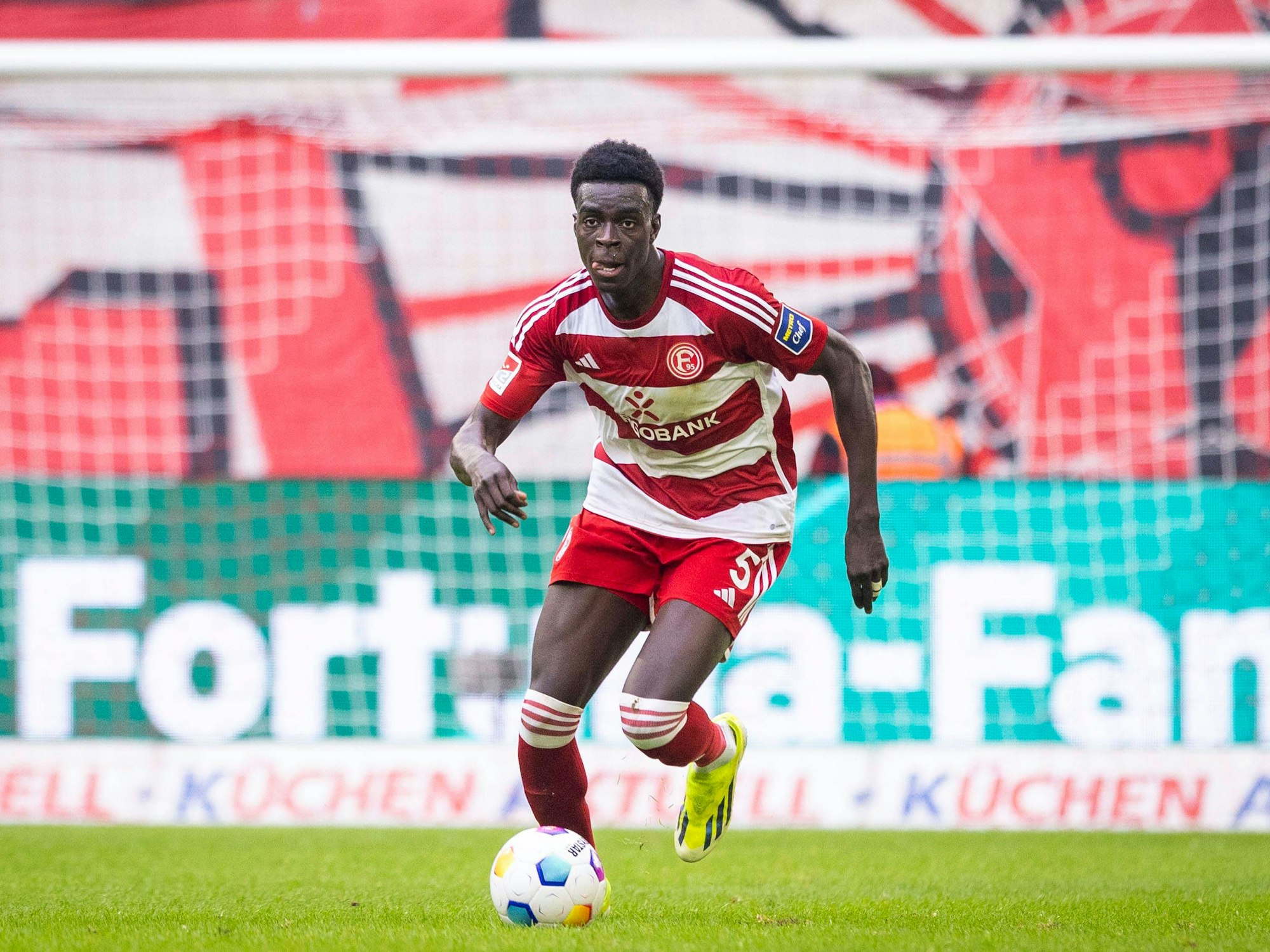 Joshua Quarshie läuft mit dem Ball über den Platz.