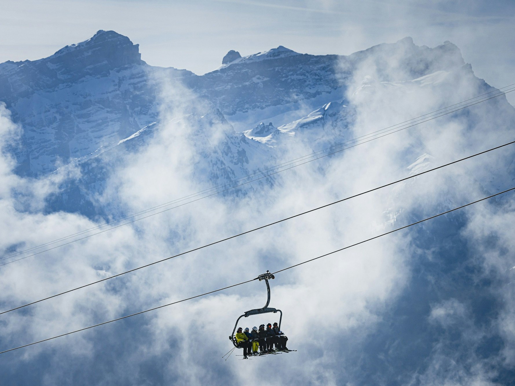 Skifahrer benutzen einen Skilift in einem Schweizer Bergdorf (Symbolbild): Viele Alpen-Skigebiete befinden sich in der Krise.
