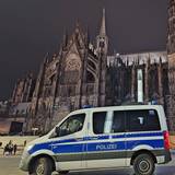 Ein Einsatzfahrzeug der Polizei steht vor dem Dom.