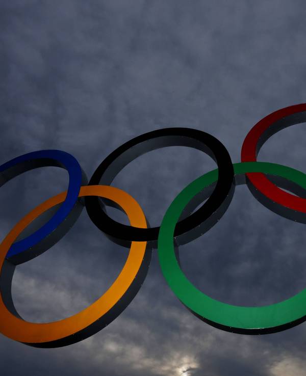 Olympische Ringe vor dunklen Wolken