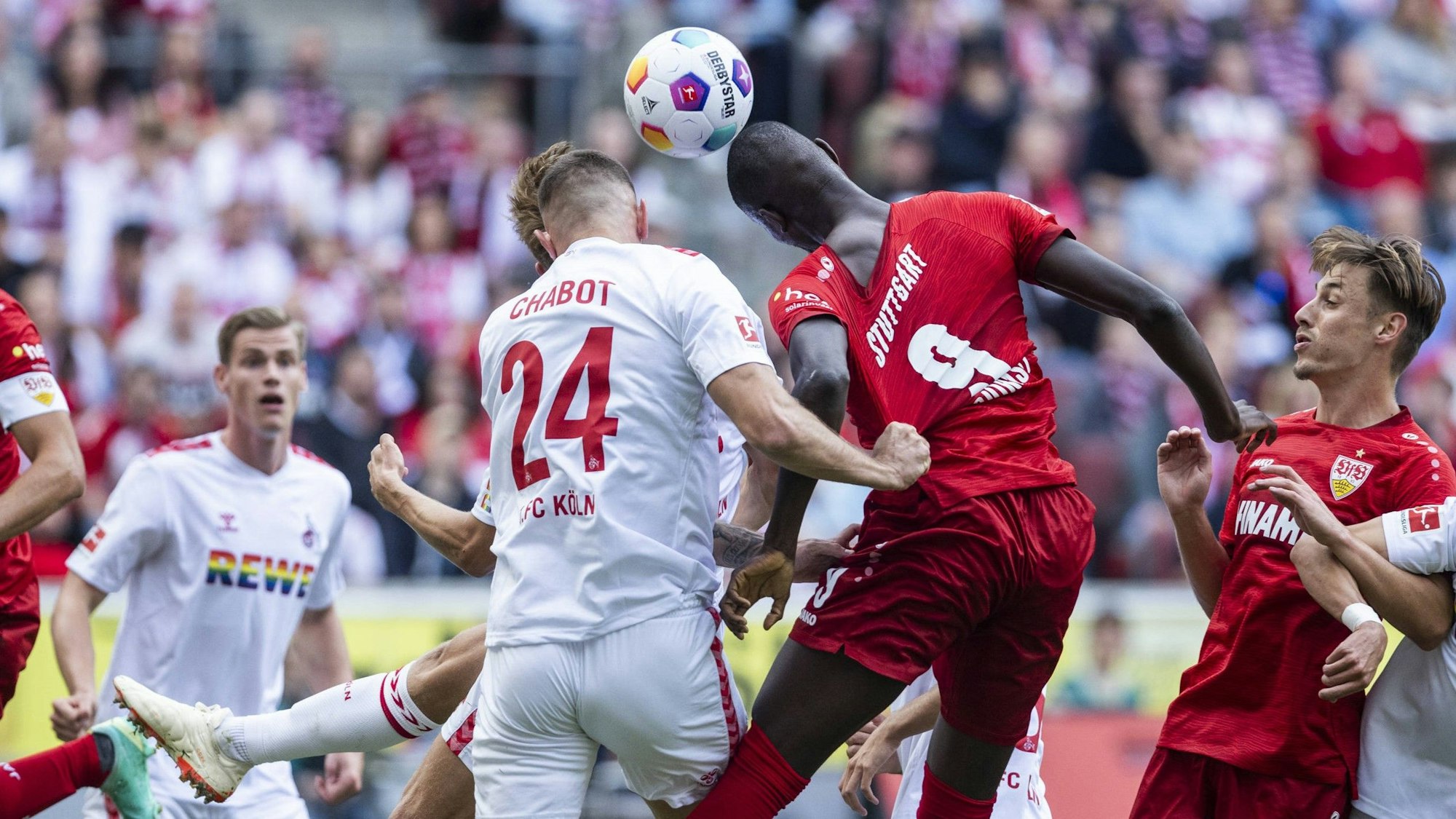 Jeff Chabot und Serhou Guirassy im Spiel zwischen dem 1. FC Köln und dem VfB Stuttgart beim engen Duell um den Ball.