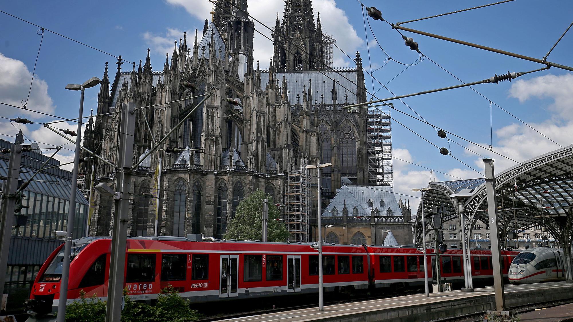 Ein Zug fährt aus Richtung Hauptbahnhof kommend am Dom vorbei.