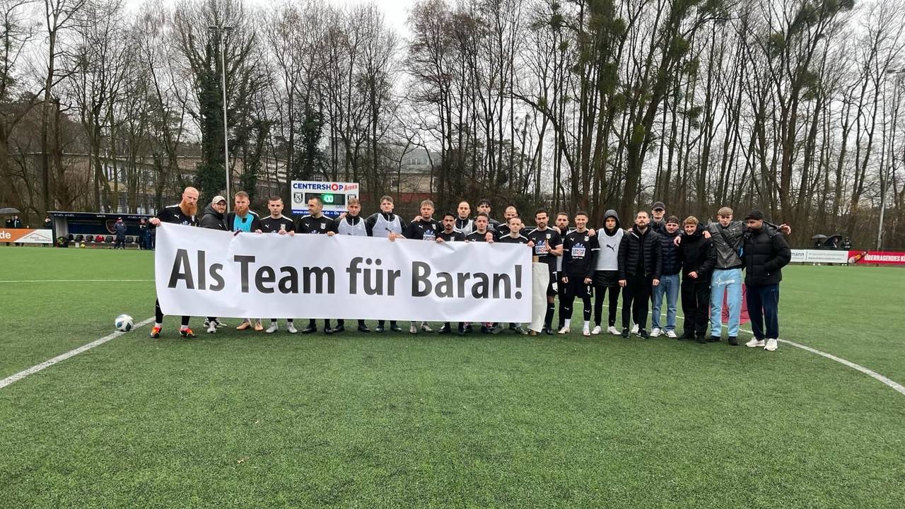 Mit dem Spruch „Als Team für Baran“ auf einem Banner zeigte sich die Mannschaft vom SSV Jan Wellem am Sonntag (18. Februar 2024) solidarisch mit ihrem entlassenen Trainer Baran Dagdelen.