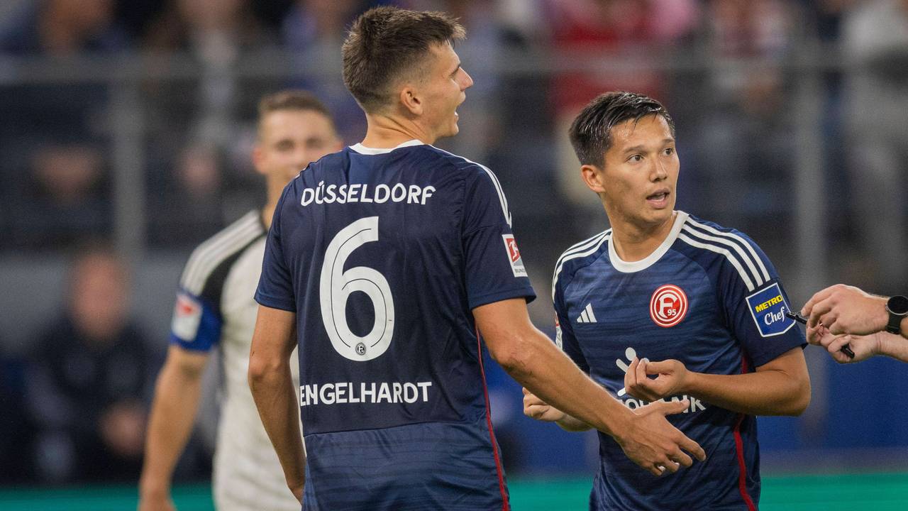 Die Düsseldorf-Profis Yannik Engelhardt und Shinta Appelkamp sprechen während des Spiels beim Hamburger SV mit dem Schiedsrichter.