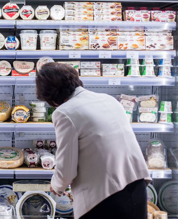 Eine Frau sortiert Käse in Köln (Archivbild 2015): Forschende warnen vor einem Ende vom Camembert-Pilz.