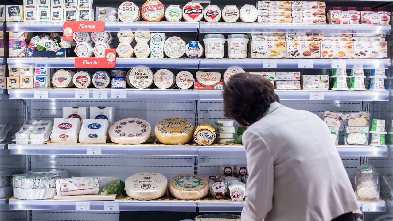 Eine Frau sortiert Käse in Köln (Archivbild 2015): Forschende warnen vor einem Ende vom Camembert-Pilz.