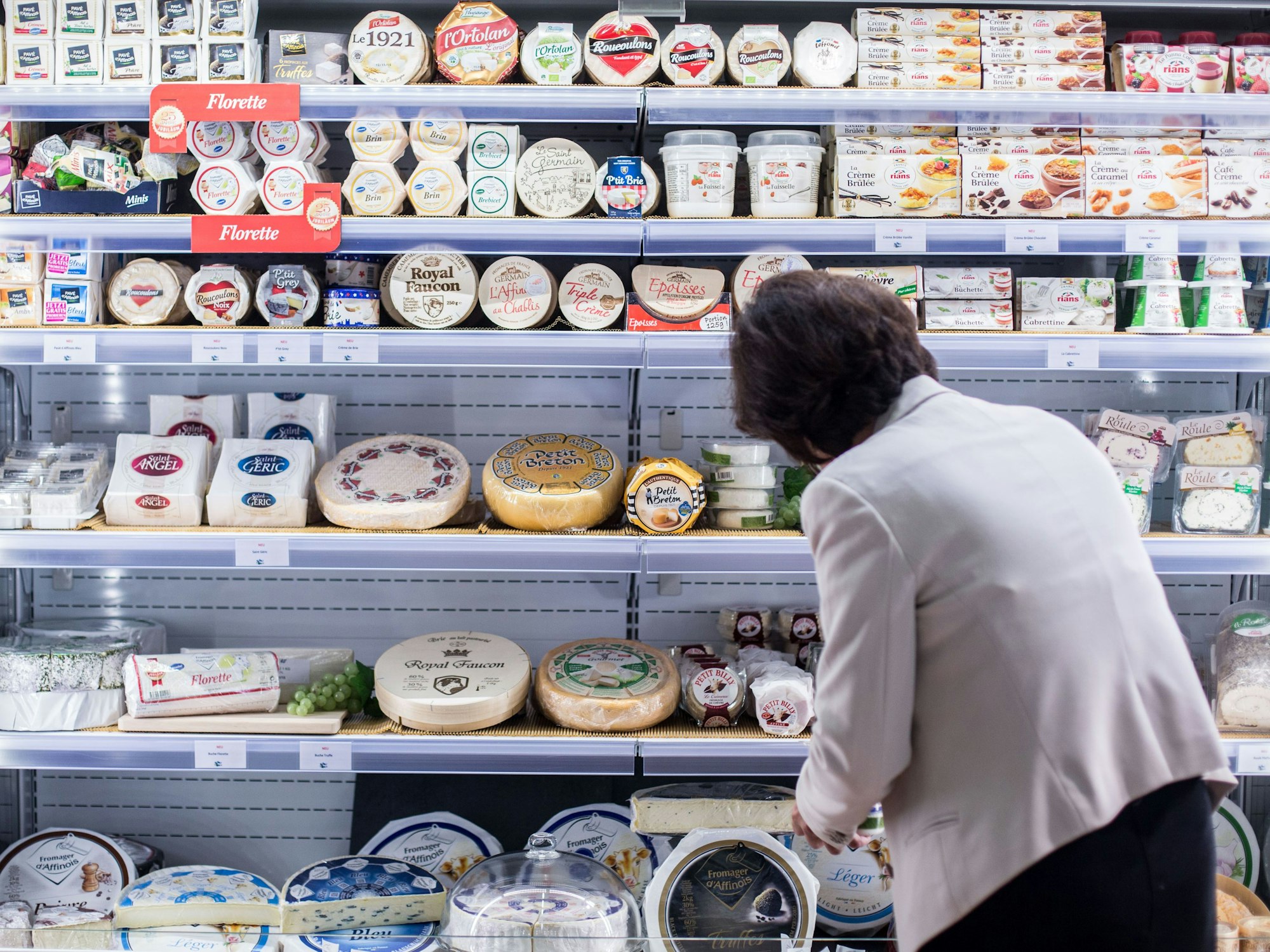 Eine Frau sortiert Käse in Köln (Archivbild 2015): Forschende warnen vor einem Ende vom Camembert-Pilz.