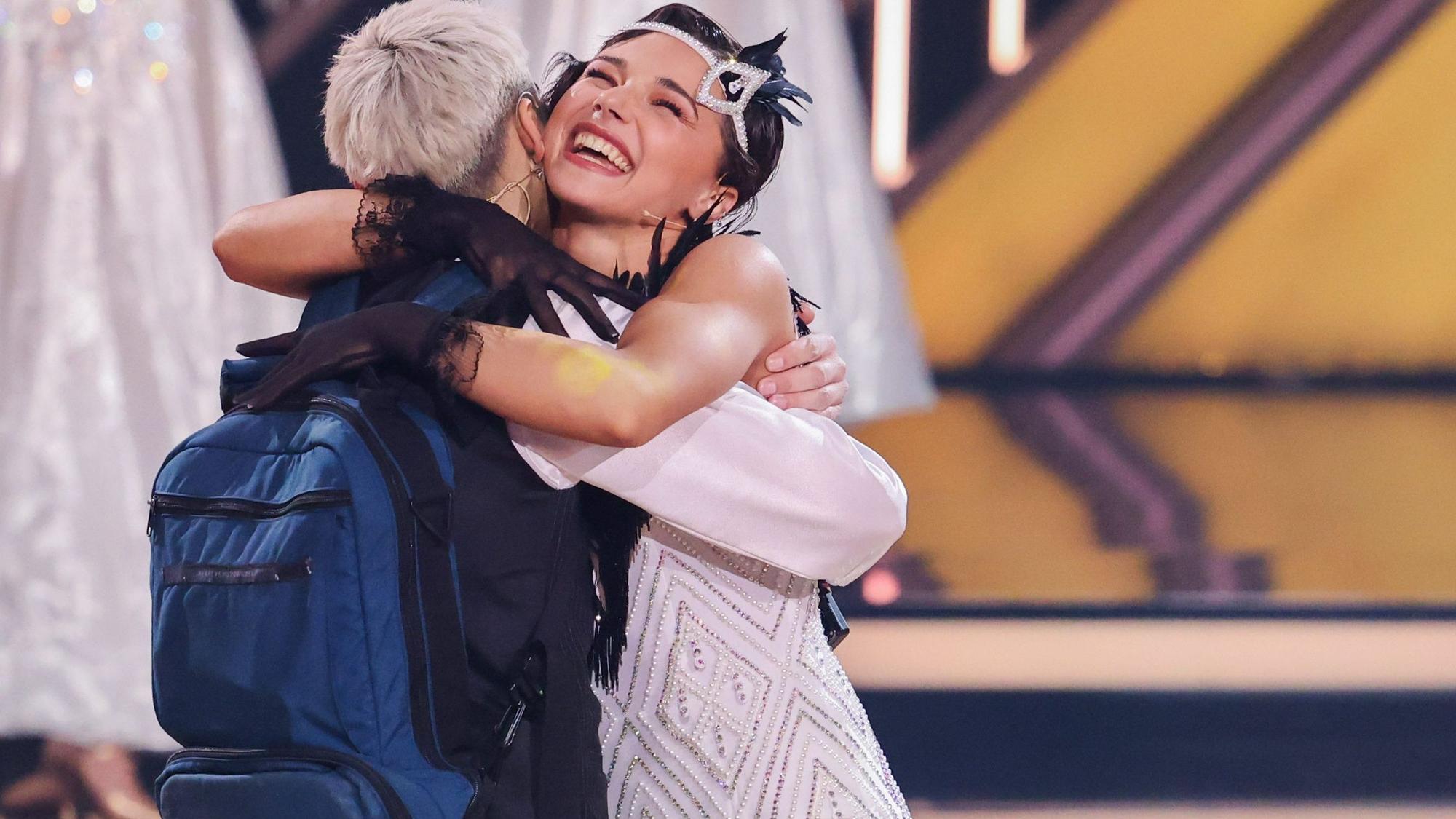 Tony Bauer trägt einen Rucksack für seine Ernährung, als er von seiner Tanzpartnerin Anastasia Stan in der Kennenlernshow umarmt wird.