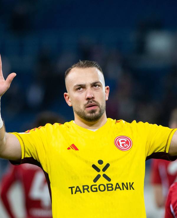 Fortuna Düsseldorfs Torwart Florian Kastenmeier hebt vor der Fankurve entschuldigend die Arme.