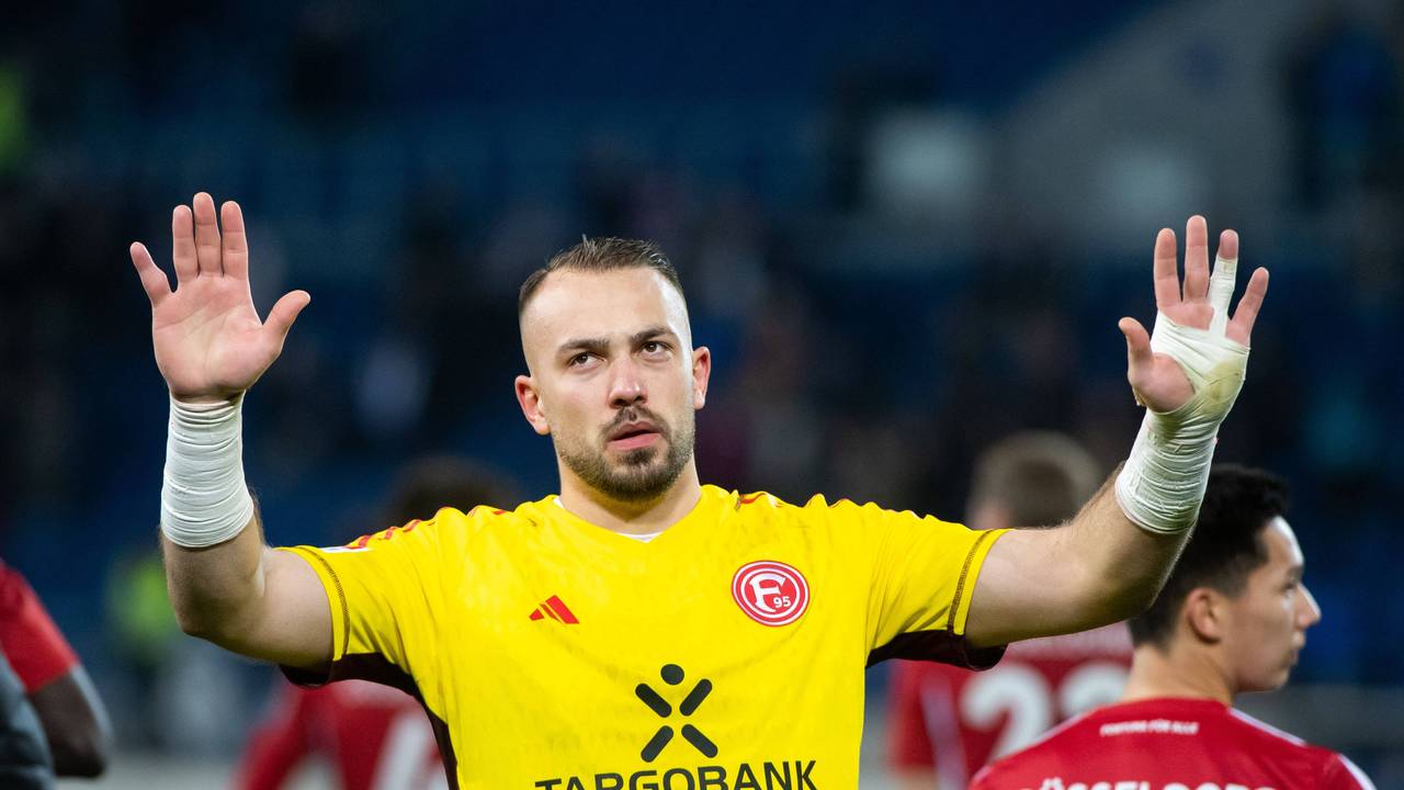 Fortuna Düsseldorfs Torwart Florian Kastenmeier hebt vor der Fankurve entschuldigend die Arme.