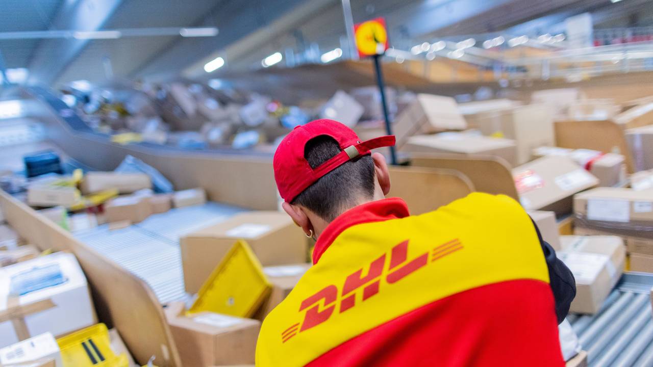 Ein Paketzusteller sortiert und räumt in einer Zustellbasis von Deutsche Post DHL Pakete in ein Zustellfahrzeug, hier im Oktober 2022 in Köln.