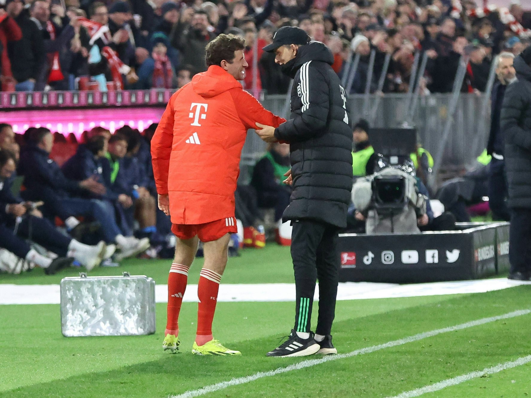 Thomas Müller und Thomas Tuchel scherzen an der Seitenlinie.