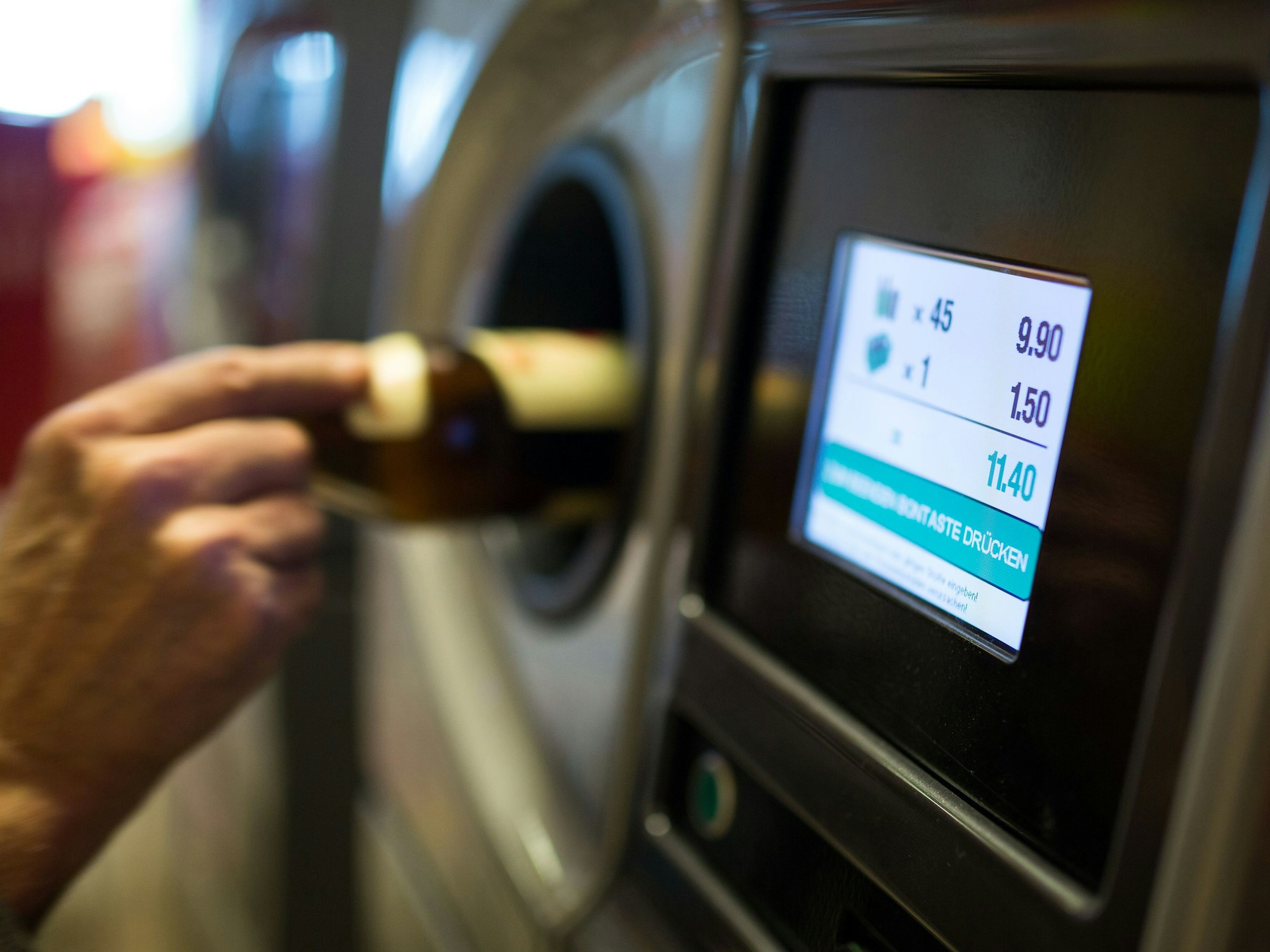 Eine Person gibt Pfandflaschen an einem Automaten ab, hier im April 2015 in Berlin.