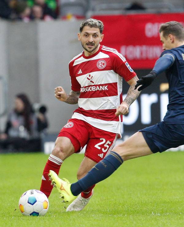 Fortuna Düsseldorfs Matthias Zimmermann passt den Ball, Hansa Rostocks Dennis Dressel will blocken.