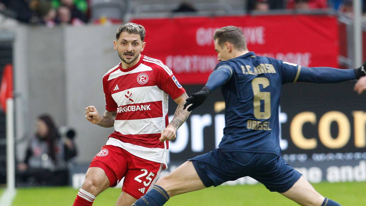 Fortuna Düsseldorfs Matthias Zimmermann passt den Ball, Hansa Rostocks Dennis Dressel will blocken.