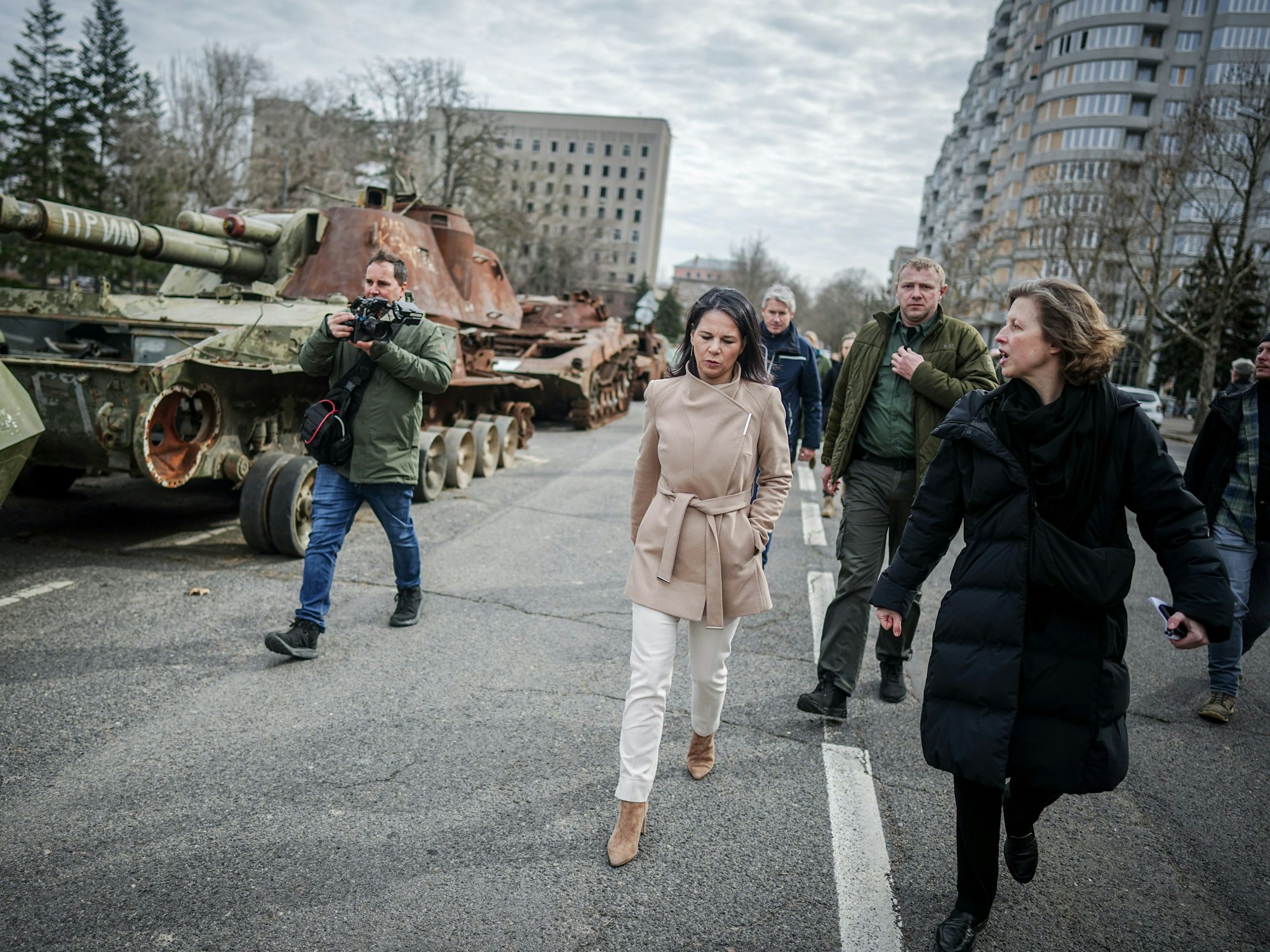 Außenministerin Annalena Baerbock geht bei ihrem Besuch des ehemaligen Sitzes der Regionalverwaltung der Oblast Mykolajiw an zerstörten russischen Panzern vorbei.