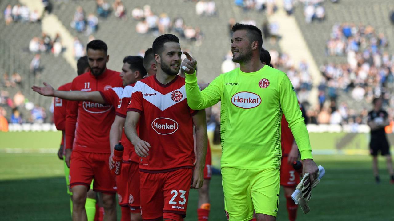 Die Düsseldorfer Profis Michael Rensing und Niko Gießelmann unterhalten sich nach dem Spiel bei Hertha BSC auf dem Platz.
