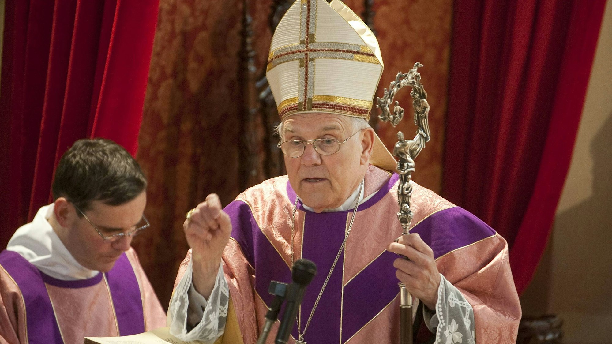 Weihbischof Klaus Dick steht am Altar und spricht.