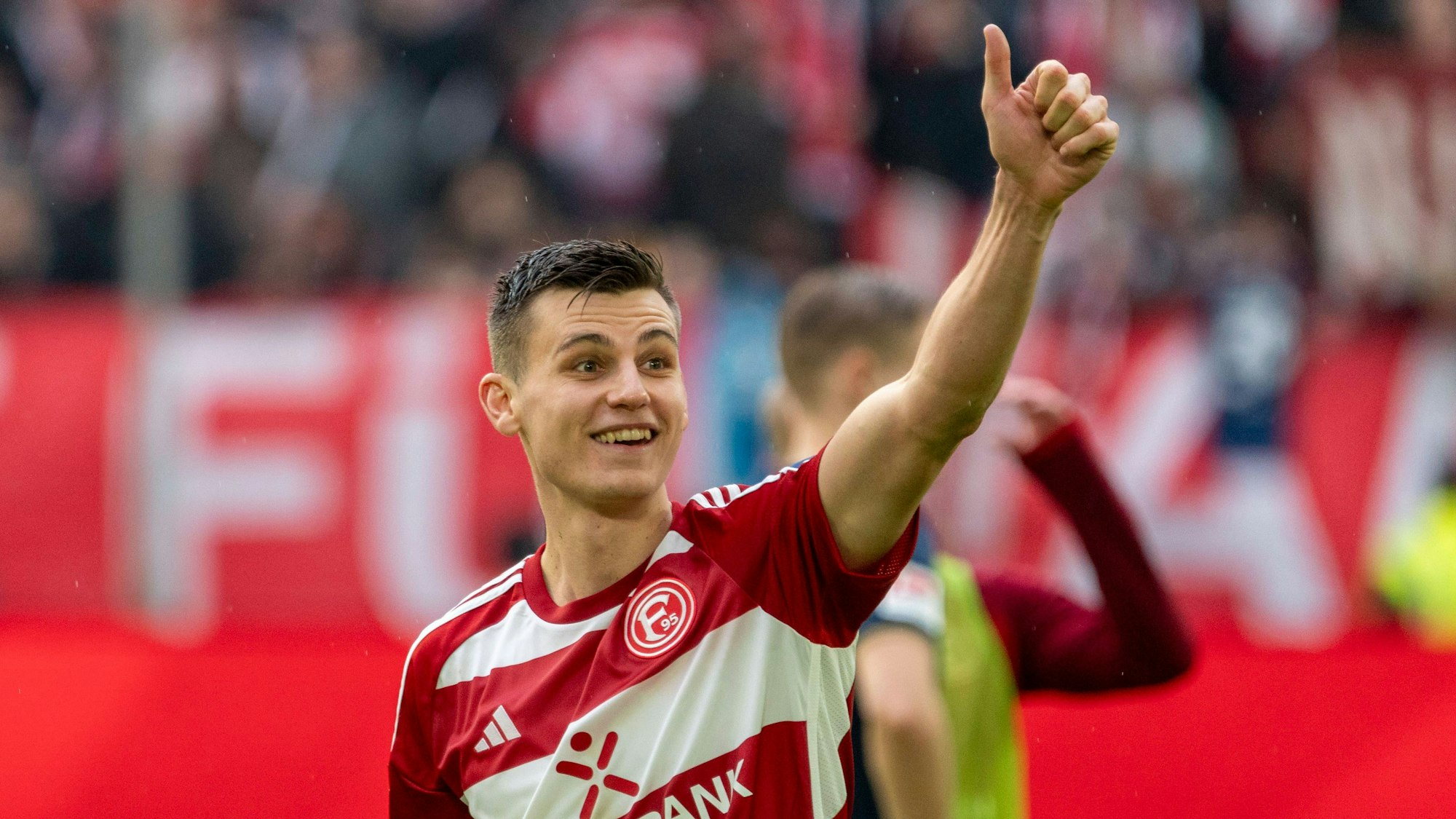 Fortuna Düsseldorfs Yannik Engelhardt hebt auf dem Spielfeld den Daumen.